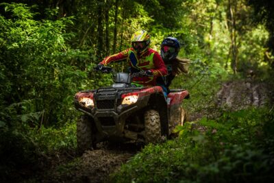 man and woman riding on ATV